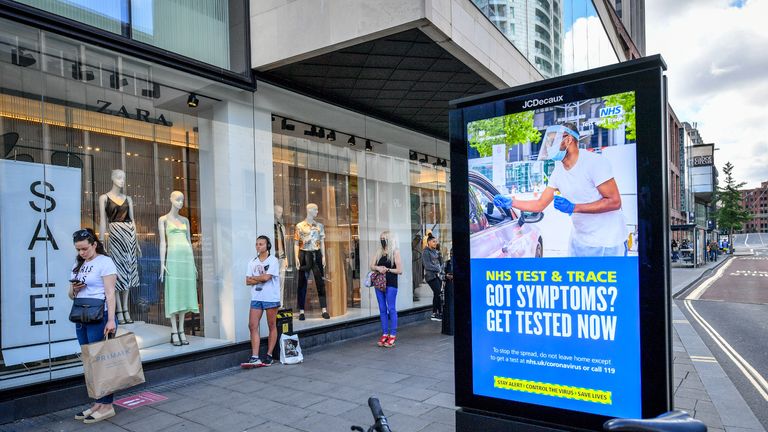 Shoppers queue beside covid advice posters in Bristol as non-essential shops in England open their doors to customers for the first time since coronavirus lockdown restrictions were imposed in March.