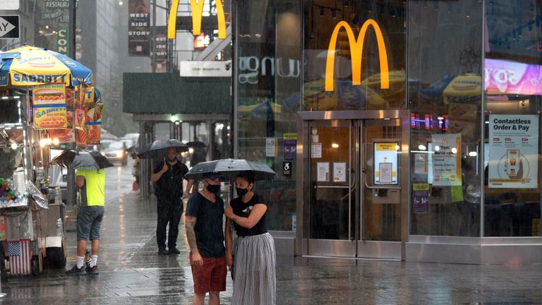 NEW YORK, NY - JULY 10: People navigate Times Square in the rain as tropical storm Fay rolls in on July 10, 2020 in New York City. Tropical storm Fay is expected to bring winds as high as 35-45 mph with gusts to 50 mph and possible flooding into Saturday morning. (Photo by David Dee Delgado/Getty Images)
