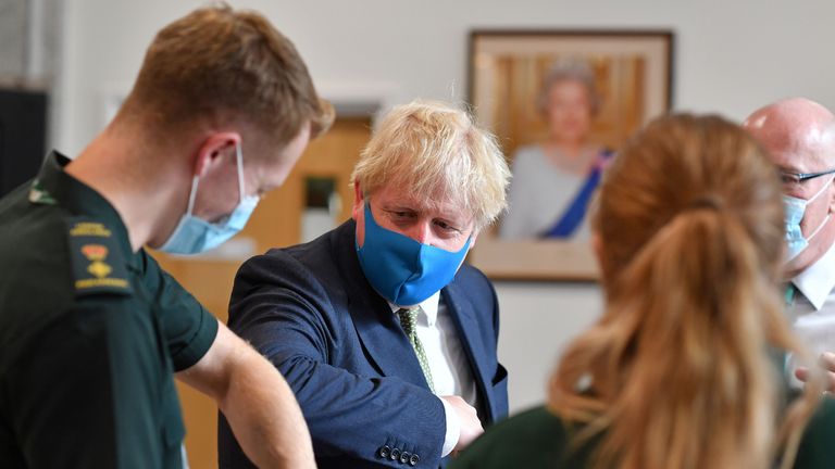 Britain's Prime Minister Boris Johnson (2L), wearing a face mask or covering due to the COVID-19 pandemic, elbow bumps a paramedic as he visits the headquarters of the London Ambulance Service NHS Trust in central London on July 13, 2020. (Photo by Ben STANSALL / POOL / AFP) (Photo by BEN STANSALL/POOL/AFP via Getty Images)