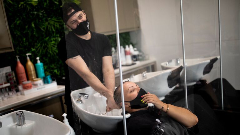 LONDON, ENGLAND - JULY 13: A customer wears a face mask while having her hair washed at a salon in Marylebone on July 13, 2020 in London, England. Nail salons, tattoo parlors and spas are among the businesses allowed to reopen today in England as the government eases the restrictions meant to curb the spread of Covid-19. (Photo by Dan Kitwood/Getty Images)