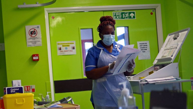 Nurse Princess Kavanire wearing a protective face mask, works on Ward D1 at the Royal Blackburn Teaching Hospital in Blackburn, north-west England on May 14, 2020, as national health service (NHS) staff in Britain fight the novel coronavirus COVID-19 pandemic. (Photo by HANNAH MCKAY / POOL / AFP) (Photo by HANNAH MCKAY/POOL/AFP via Getty Images)