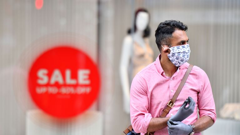 A man wearing a face covering and gloves as precautions against the transmission of the novel coronavirus crosses Oxford Street in London on July 14, 2020. - Face masks will be compulsory in shops and supermarkets in England from next week, the government said on July 14, in a U-turn on previous policy. (Photo by JUSTIN TALLIS / AFP) (Photo by JUSTIN TALLIS/AFP via Getty Images)