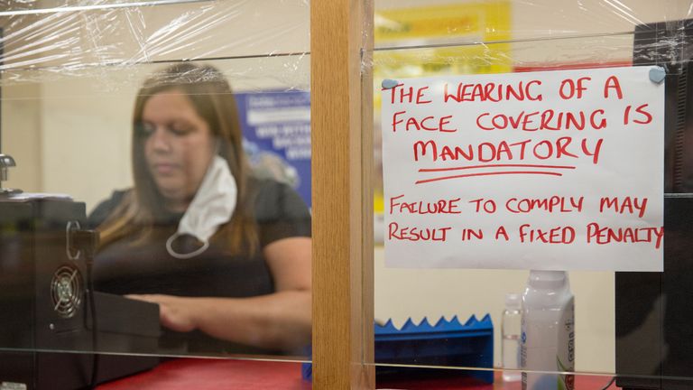 CHAPELHALL, SCOTLAND - JULY 22: A notice instructing customers to wear face masks next to Natalie McLaughlan, manager of the Scotbet Independent bookmakers shop, as coronavirus measures are relaxed to allow televisions and seating inside betting shops on July 22, 2020 in Chapelhall, Scotland. Independent Bookmakers are concerned that they will put out of business through a lack of help from the Scottish government during the Coronavirus pandemic. The Betting and Gaming Council (BGC) has called for Scotland to follow the lead of the UK Government and make betting shops eligible for rates relief. (Photo by Robert Perry/Getty Images)