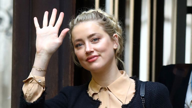 Amber Heard waves to fans as she enters the High Court to give evidence for a third day