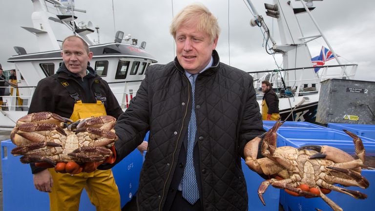 Prime Minister Boris Johnson holds crabs caught on the Carvela with Karl Adamson at Stromness Harbour  in Stromness during a visit to the Highlands and Northern Isles of Scotland