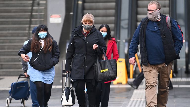 People are seen walking through Melbourne where face-coverings are compulsory 