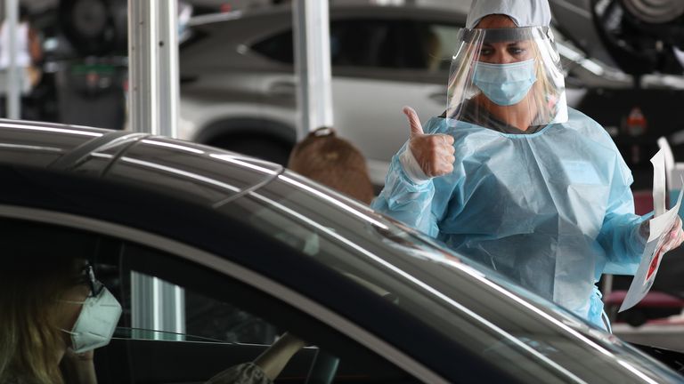 A health care worker gives a thumbs up at a testing site in Florida
