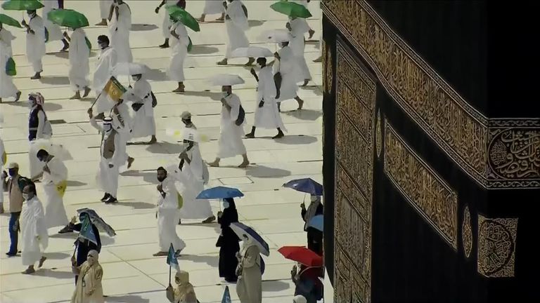 Pilgrims, wearing face masks and moving in small groups walk around the Kaaba, Mecca&#39;s holiest site