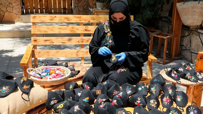 A women near Hebron makes face masks - people in the West Bank have also been told to stay home