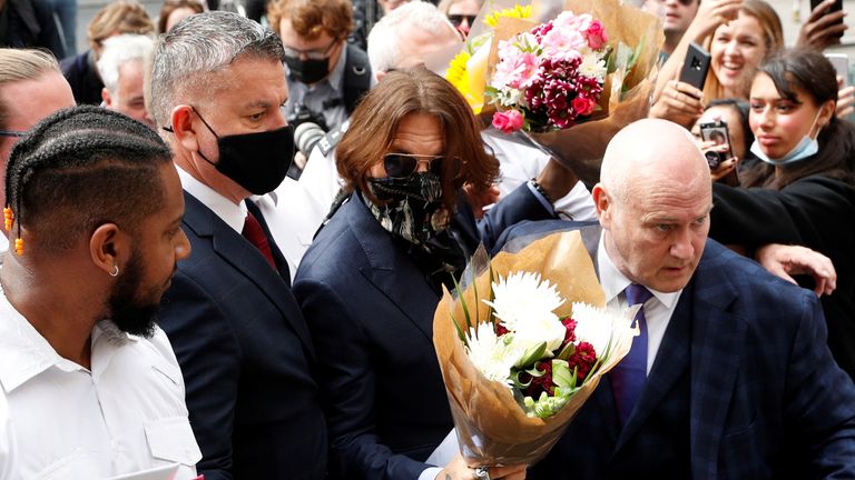 Johnny Depp is given flowers as he arrives at the High Court on 24 July