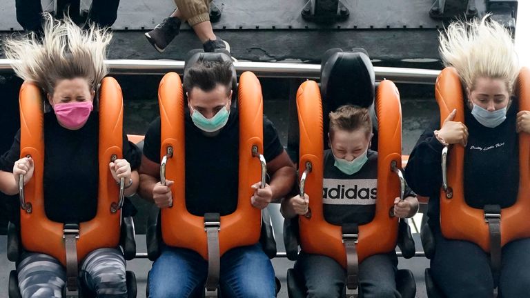 Members of the public wear face masks as they ride the "Oblivion" rollercoaster at Alton Towers on July 4, 2020 in Alton, England. The popular theme park reopens with coronavirus safety measures in place today, after the British government eased the coronavirus restrictions in England to allow some leisure and hospitality businesses to reopen after more than 3 months in lockdown
