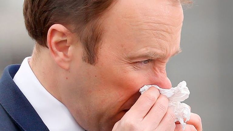 Britain&#39;s Health Secretary Matt Hancock (R) blows his nose during the opening of the "NHS Nightingale" field hospital, created at the ExCeL London exhibition centre, in London on April 3, 2020, to help with the novel coronavirus COVID-19 pandemic. - The new state-run National Health Service (NHS) hospital, named after trailblazing 19th-century nurse Florence Nightingale, has been built in just nine days. (Photo by Tolga AKMEN / AFP) (Photo by TOLGA AKMEN/AFP via Getty Images)
