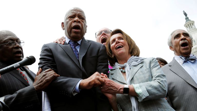 Mr Lewis holds hands with Nancy Pelosi during a sit-in on Capitol Hill over gun-control law 