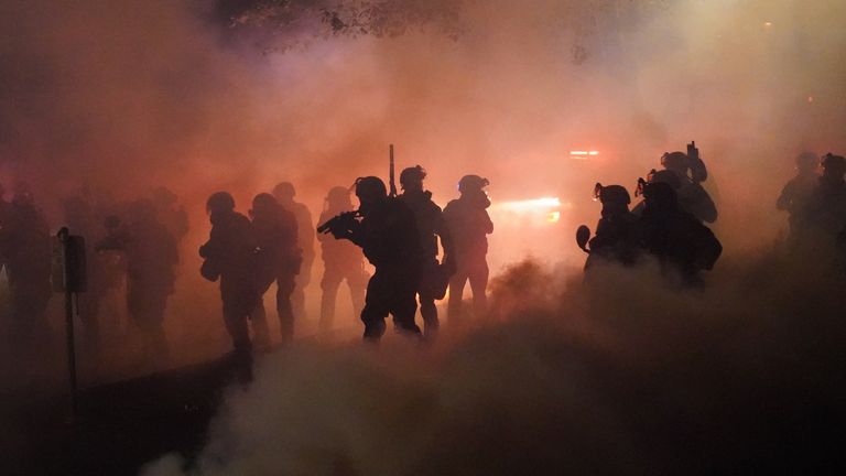 Federal officers use tear gas on a crowd of about 1,000 protesters in front of the Portland courthouse