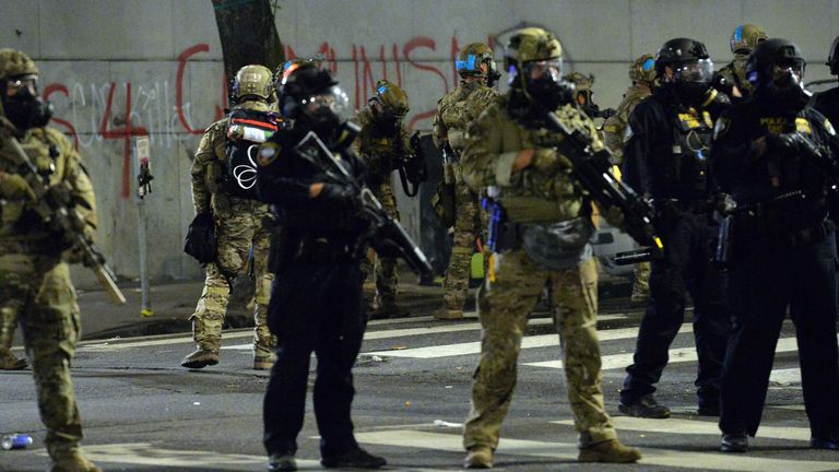 Some of the federal officers wear camouflague, others have dressed in all black