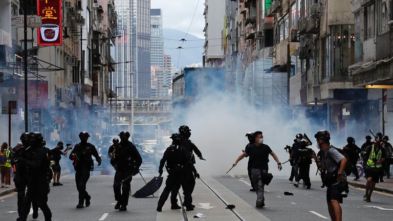 Riot police fire tear gas into the crowds to disperse anti-national security law protesters during a march at the anniversary of Hong Kong&#39;s handover to China from Britain in Hong Kong, China