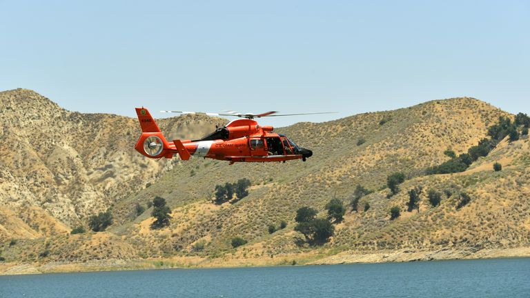 A U.S. Coast Guard helicopter flies over Lake Piru