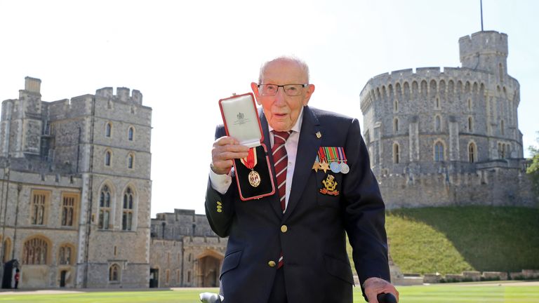 Sir Tom proudly shows off his  medal