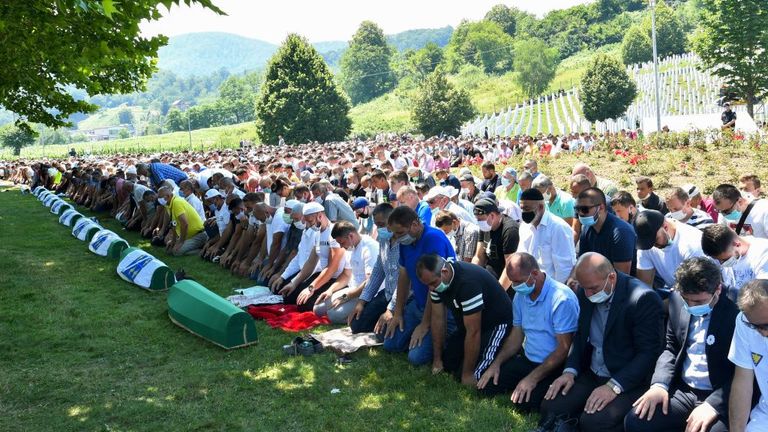 Bosnian Muslim men wearing face masks mark the 25th anniversary of the Srebrenica massacre