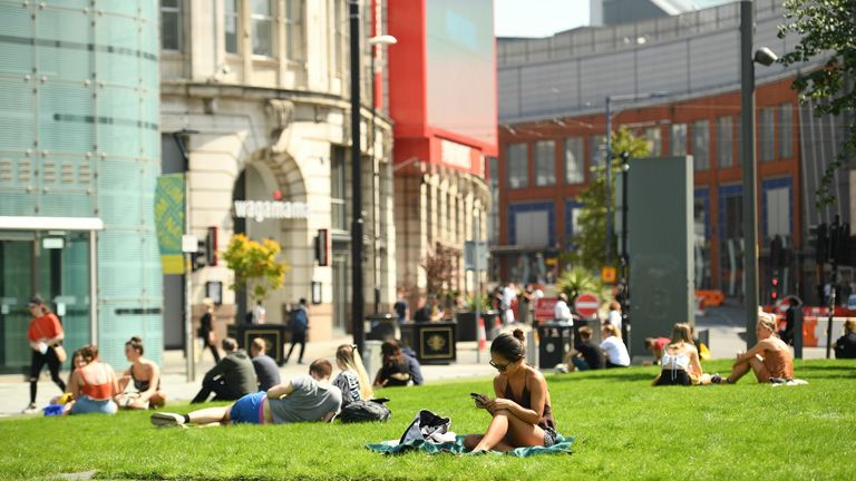 People relax in the warm weather in Manchester