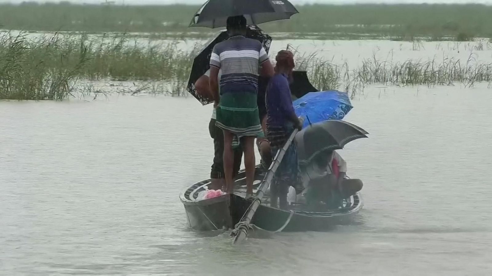 People use a canoe to escape floodwaters in Bangladesh