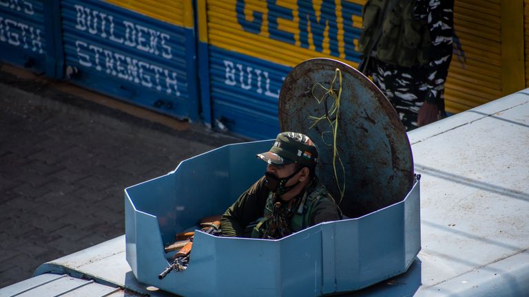 SRINAGAR, KASHMIR - INDIA - AUGUST 05: An Indian paramilitary trooper guards atop his armored vehicle in a deserted city square,  during a curfew like restrictions, a year after India revoked the special status of Jammu and Kashmir, on August 05, 2020  in Srinagar, the summer capital of Indian administered Kashmir, India. Indian police and paramilitary personnel were deployed in strength as authorities imposed curfew-like restrictions in summer capital city Srinagar  on the first anniversary of the Indian government stripping the Himalayan region, contested by both India and Pakistan since 1947, of its autonomy and downgrading its status from a state to a union  territory in a stealth move last year. The region is already reeling under a lockdown imposed by authorities to curb the spread of coronavirus. (Photo by Yawar Nazir/Getty Images)