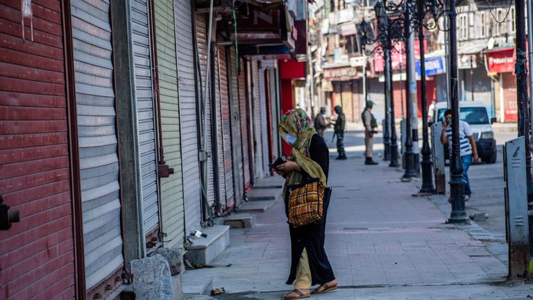 SRINAGAR, KASHMIR - INDIA - AUGUST 05: A Kashmiri Muslim woman walks in the deserted city square during a curfew like restrictions, a year after India revoked the special status of Jammu and Kashmir, in the city center  on August 05, 2020  in Srinagar, the summer capital of Indian administered Kashmir, India. Indian police and paramilitary personnel were deployed in strength as authorities imposed curfew-like restrictions in summer capital city Srinagar  on the first anniversary of the Indian government stripping the Himalayan region, contested by both India and Pakistan since 1947, of its autonomy and downgrading its status from a state to a union  territory in a stealth move last year. The region is already reeling under a lockdown imposed by authorities to curb the spread of coronavirus. (Photo by Yawar Nazir/Getty Images)