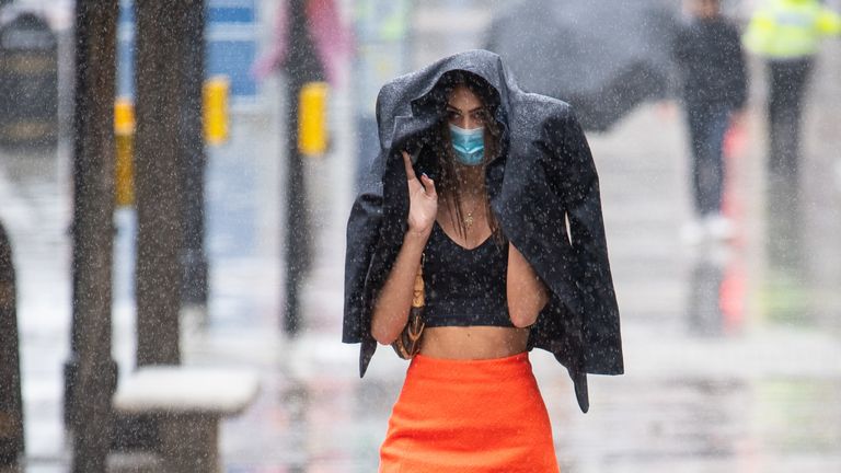 A shopper gets caught in a heavy downpour of rain on Oxford Street, London, as sunshine and showers are forecast for much of England and Wales on Saturday, with temperatures expected to hover around 22C (71.6F).