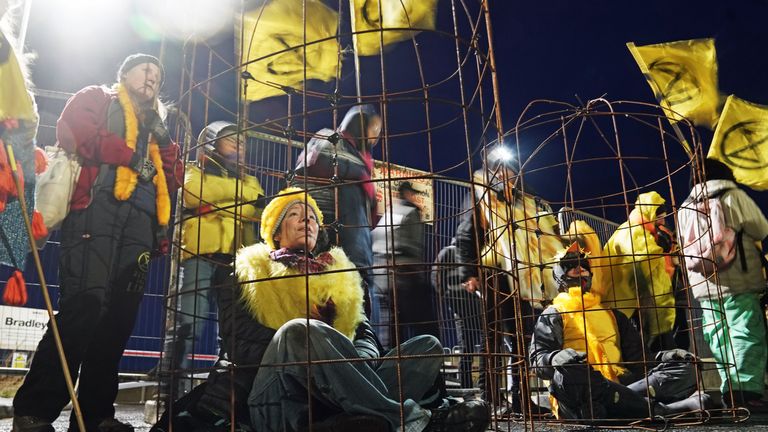Protesters - some dressed as canaries in a cage - during an Extinction Rebellion action to stop the expansion of Bradley open-cast coal mine in County Durham.