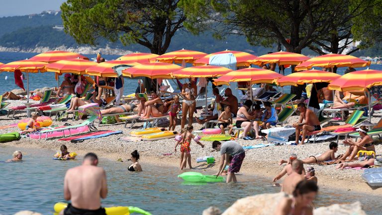 Crowds of people, mostly foreign tourists, sunbath and swim in the sea on August 13, 2020, in Crikvenica on the northern Adriatic coast. - On August 13, 180 new cases of coronavirus infection have been recorded in Croatia, the highest since the beginning of the pandemic. Italy has already introduced mandatory testing for all who come from Croatia. (Photo by DENIS LOVROVIC / AFP) (Photo by DENIS LOVROVIC/AFP via Getty Images)