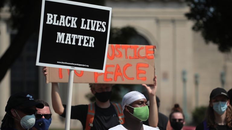 KENOSHA, WISCONSIN - AUGUST 24: A Black Lives Matter sign is held up as people gather in front of the police station the day after a Black man was shot by police causing outrage and local unrest in the city on August 24, 2020 in Kenosha, Wisconsin. Kenosha Police shot a Black man multiple times in the back yesterday night as he entered the driver's side door of a vehicle. The man reportedly identified as Jacob Blake, was hospitalized in Milwaukee in serious condition. (Photo by Scott Olson/Getty Images)