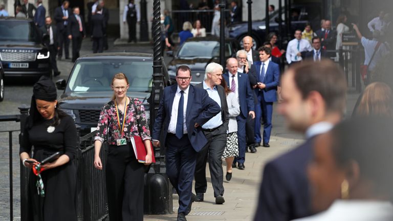 Members of Parliament queue outside the House of Commons in Westminster, London, as they wait to vote on the future of proceedings, amid a row over how Commons business can take place safely.