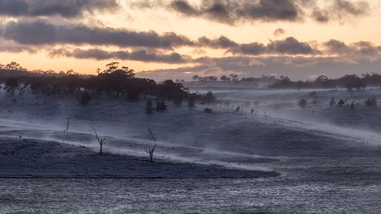 A heavy blanket of snow is seen at dawn over Lake Eucumbene near Old Adaminaby