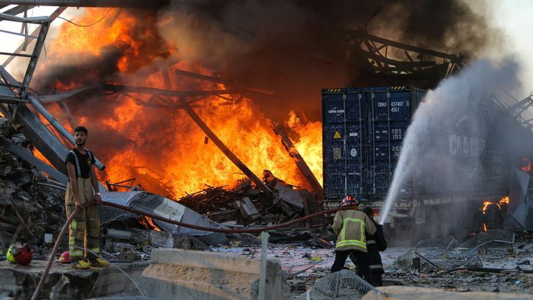 Firefighter douse a blaze at the scene of an explosion at the port of Lebanon&#39;s capital Beirut on August 4, 2020. - Two huge explosion rocked the Lebanese capital Beirut, wounding dozens of people, shaking buildings and sending huge plumes of smoke billowing into the sky. Lebanese media carried images of people trapped under rubble, some bloodied, after the massive explosions, the cause of which was not immediately known. (Photo by STR / AFP) (Photo by STR/AFP via Getty Images)