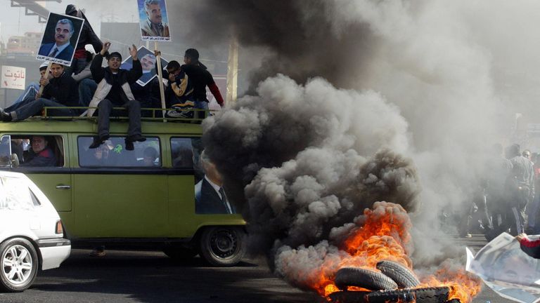 People carry posters of assassinated former Lebanese PM Rafiq Hariri during an anti-government protest in 2005