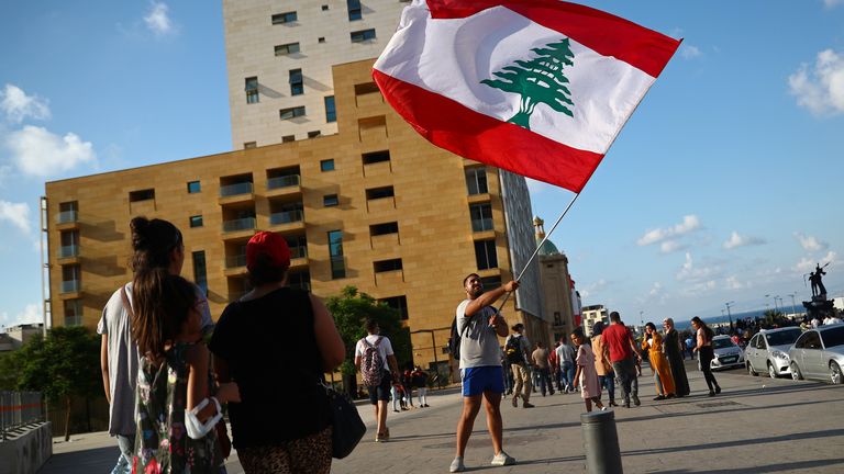 A demonstrator waves a Lebanese flag during a protest in Beirut, Lebanon