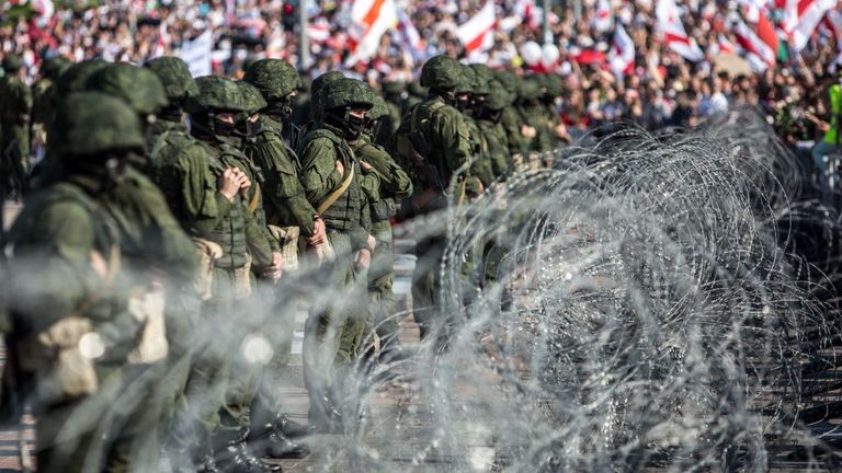 Belarussische Soldaten stehen hinter einem Stacheldrahtzaun während einer Kundgebung der Oppositionsanhänger, die gegen die umstrittenen Präsidentschaftswahlen in Minsk am 30. August 2020 protestiert. - Zehntausende Anhänger der Opposition marschierten am 30. August durch Minsk und forderten ein Ende der Herrschaft des starken Mannes Alexander Lukaschenko inmitten einer starken Sicherheitspräsenz und trotz Dutzender Verhaftungen. Die Proteste in Belarus sind in eine dritte Woche seit den umstrittenen Präsidentschaftswahlen am 9. August eingetreten, in denen Lukaschenko