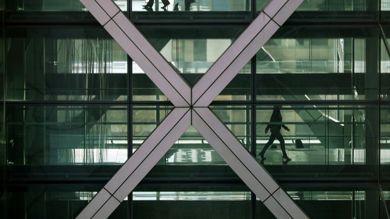 eople walk in an office in the financial centre of Canary Wharf 