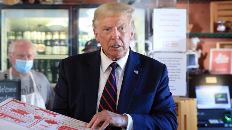 Donald Trump holds a pizza in a box