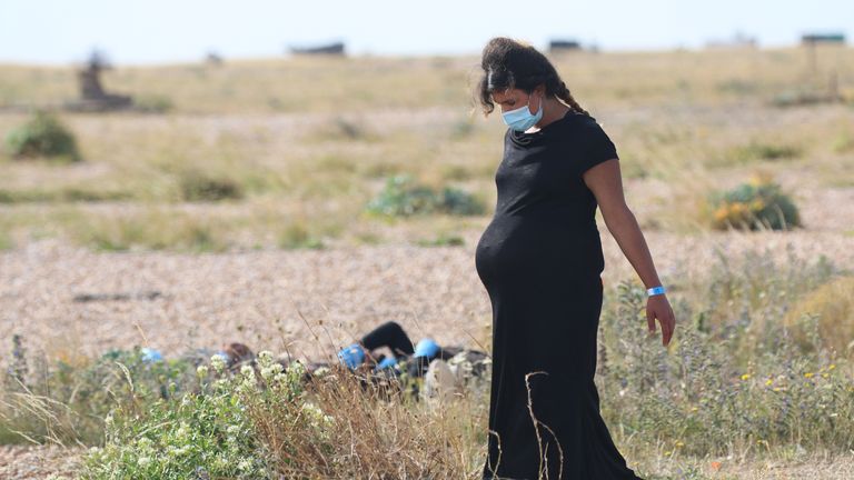 A pregnant woman walks near the coast of Dungeness after arriving in the UK. Pic: Susan Pilcher 