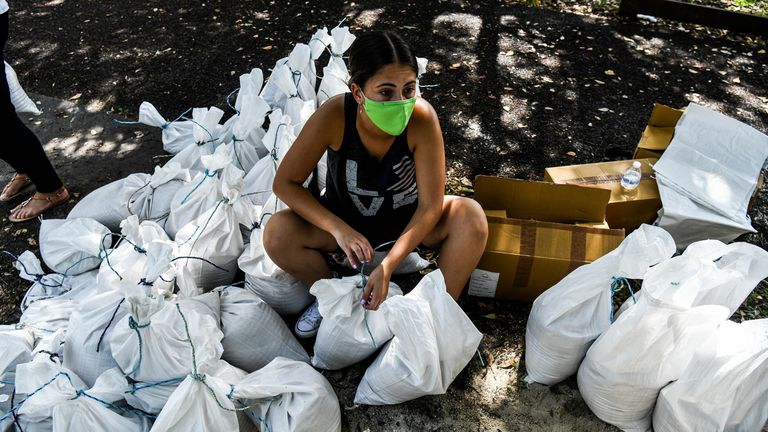 A woman prepares sand bags for distribution to the residents of Palmetto Bay near Miami
