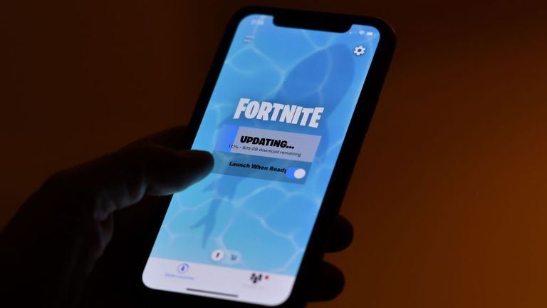 This illustration picture shows a person waiting for an update of Epic Games&#39; Fortnite on their smartphone in Los Angeles on August 14, 2020. - Apple and Google on August 13, 2020 pulled video game sensation Fortnite from their mobile app shops after its maker Epic Games released an update that dodges revenue sharing with the tech giants. (Photo by Chris DELMAS / AFP) (Photo by CHRIS DELMAS/AFP via Getty Images)
