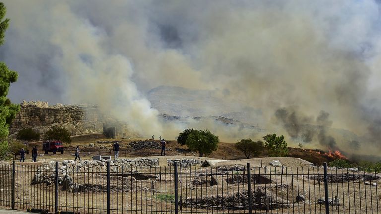 Smoke from a wildfire billows over the ancient city of Mycenae