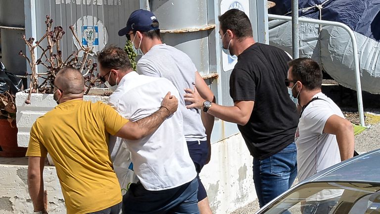 Harry Maguire, in the blue cap, at a police station on Syros.
Pic: Athena Pictures