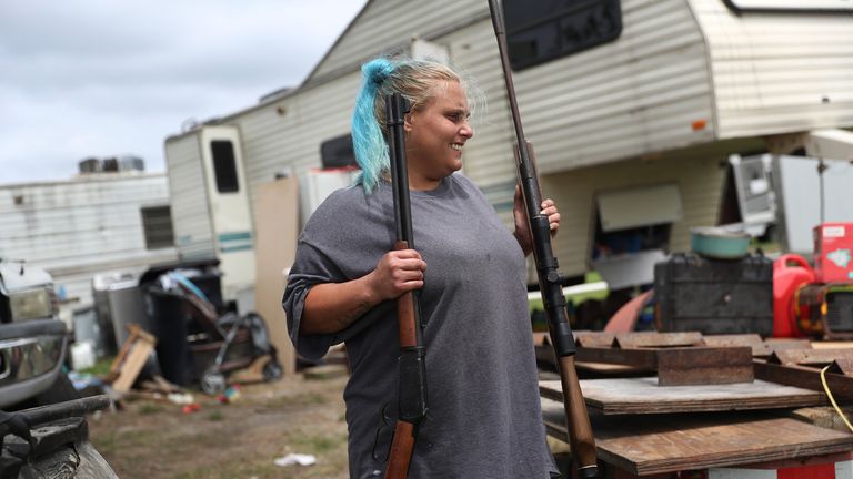 A woman emoves rifles from her home as she evacuates before the possible arrival of Hurricane Laura, in Cameron, Louisiana