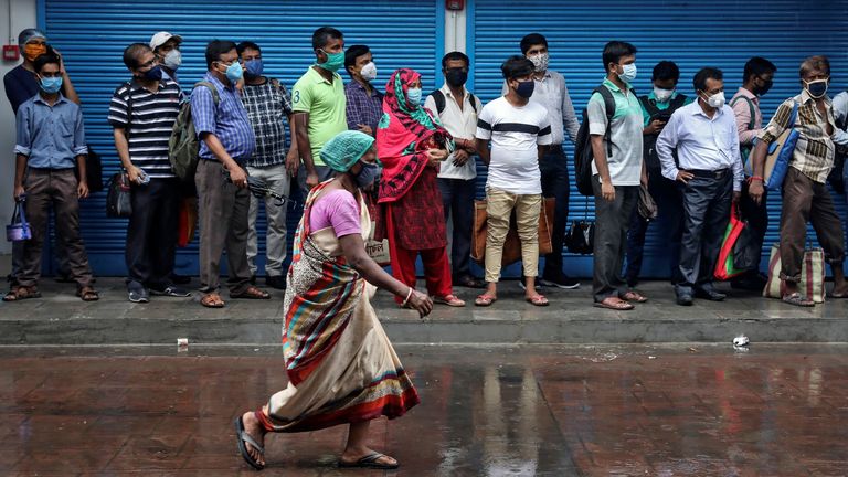 People queue for a bus in Kolkata