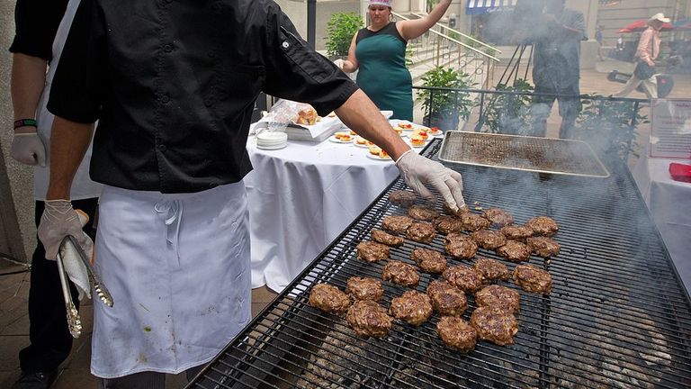 A cook grills grasshopper burgers June 4, 2014 during a global Pestaurant event sponsored by Ehrlich Pest Control, held at the Occidental Restaurant in Washington, DC. For one day only, pop-up Pestaurants will appear in cities across the globe to offer sweet and savoury edible insects, grasshopper burgers and much more. Ehrlich Pest Control will be donating $5 USD to DC Central Kitchen for every person who eats something at the event. AFP PHOTO / Karen BLEIER (Photo credit should read KAREN BLEI