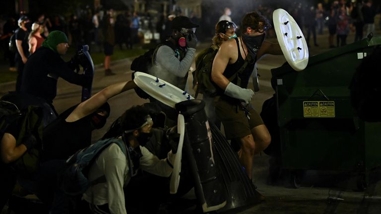 People hold up makeshift shields as they protest outside the Kenosha County Courthouse after a Black man, identified as Jacob Blake, was shot several times by police in Kenosha, Wisconsin, U.S. August 25, 2020. REUTERS/Stephen Maturen