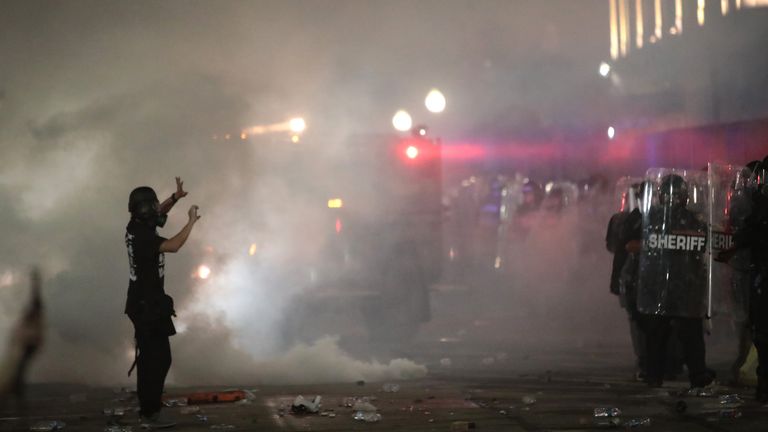 KENOSHA, WISCONSIN - AUGUST 25: As tear gas fills the air, demonstrators confront police in front of the Kenosha County Courthouse during a third night of unrest on August 25, 2020 in Kenosha, Wisconsin. Rioting as well as clashes between police and protesters began Sunday night after a police officer shot Jacob Blake seven times in the back in front of his three children. (Photo by Scott Olson/Getty Images)