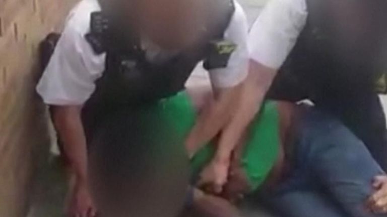 Video has emerged showing a man being detained by two police officers with one appearing to place his knee on the suspect&#39;s neck.